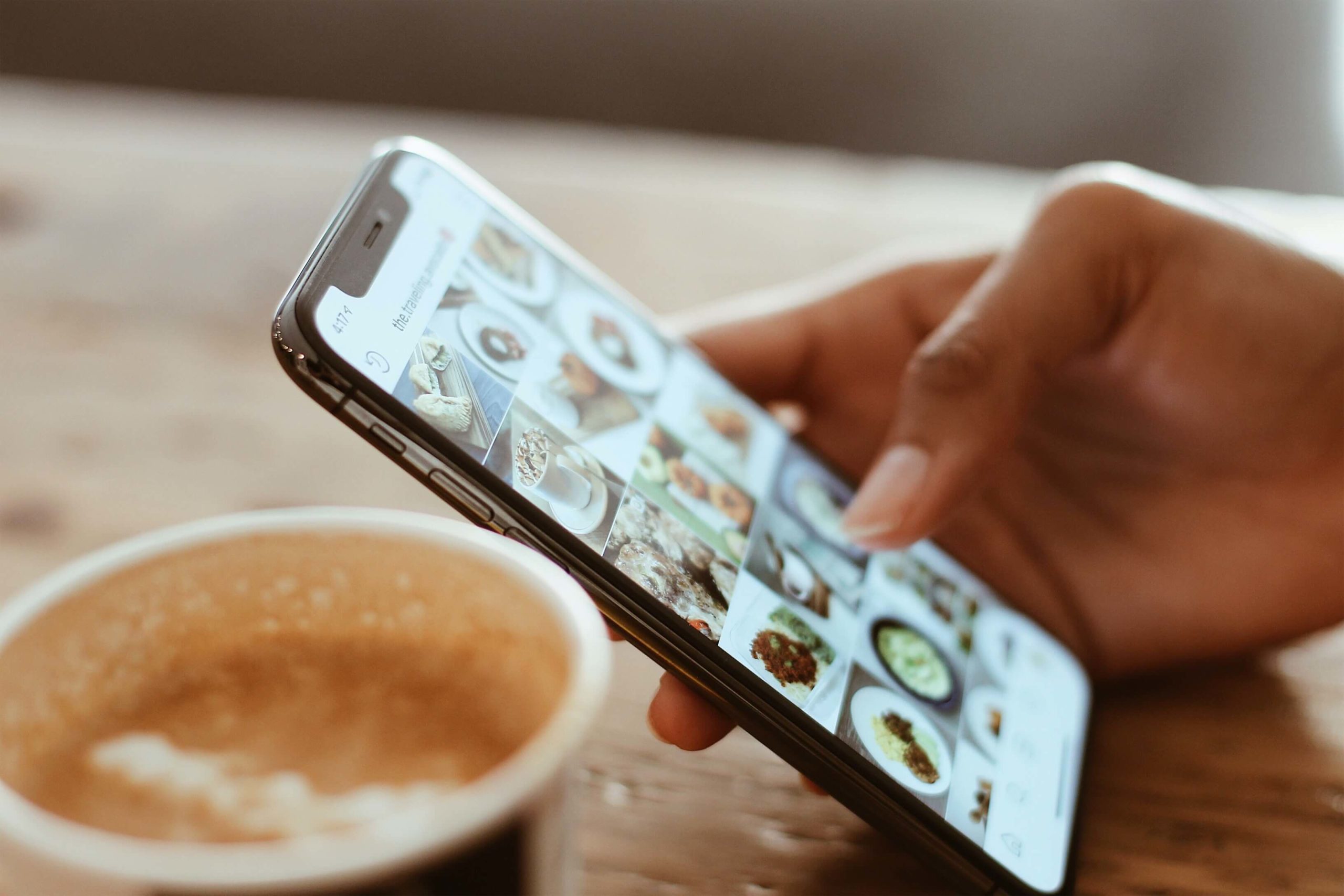 hand holding a phone scrolling through social posts